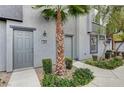 Townhouse entryway with grey door and landscaping at 9050 W Tropicana Ave # 1080, Las Vegas, NV 89147