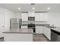 Modern kitchen with white cabinets and gray island at 1720 Desert Path Ave, North Las Vegas, NV 89032