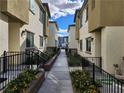 Shared walkway between townhouses, with landscaping and fencing at 12369 Golden Wreath Rd # 2, Las Vegas, NV 89183