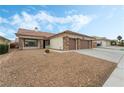 House exterior with a three car garage and desert landscaping at 5301 Clouds Rest Ave, Las Vegas, NV 89108