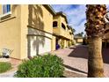 Building exterior showcasing attached garages and desert landscaping at 1605 Crimson Hills Dr # 204, Las Vegas, NV 89128