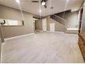 Open living room with light gray wood-look tile floors and a staircase at 2678 Aracatuba Ave, Las Vegas, NV 89121