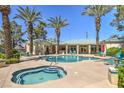 Community pool and spa area with palm trees and lounge chairs at 5155 W Tropicana Ave # 1052, Las Vegas, NV 89103