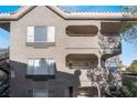 Two-story stucco building with multiple balconies and a tree at 701 Capri Dr # 6C, Boulder City, NV 89005