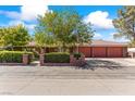 Brick home with three-car garage and manicured landscaping at 3841 Hildebrand Ln, Las Vegas, NV 89121