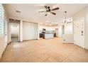 Open living room with kitchen view, tile floors, and ceiling fans at 928 Crescent Falls St, Henderson, NV 89011