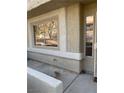 Exterior view of a light beige stucco home with a blue garage door and carport at 2208 Rugged Mesa Dr, Laughlin, NV 89029