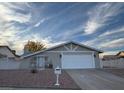 Tan house with white garage door and gated entryway at 617 Hidden Valley Dr, Henderson, NV 89002