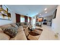 Open concept living room with a sectional sofa and a view into kitchen at 417 Desert Cadence St, Henderson, NV 89011