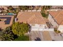 Aerial view of a two-story house with a tile roof, large yard, and a three-car garage at 1430 October Oak Ave, Las Vegas, NV 89123