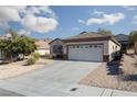 Single-story home with two-car garage and desert landscaping at 2516 Cosmic Dust St, Henderson, NV 89044