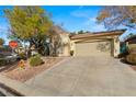 Tan stucco home with a two-car garage and desert landscaping at 498 Canyon View Way, Mesquite, NV 89027