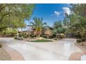 Single-story home with circular driveway, landscaping, and gated entry at 7110 Crowntop Cir, Las Vegas, NV 89118