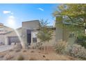 Modern home with gray exterior, dark garage door, and landscaped front yard at 6841 Fallen Rock St, North Las Vegas, NV 89084