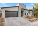 Modern home with gray exterior, dark garage door, and landscaped front yard at 6841 Fallen Rock St, North Las Vegas, NV 89084