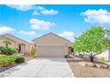 Tan house with a two-car garage and desert landscaping at 577 Cypress Gardens Pl, Henderson, NV 89012