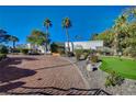 Landscaped grounds with putting green and brick driveway leading to a single-story home at 8480 W Ann Rd, Las Vegas, NV 89149