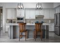 Modern kitchen with white cabinets, stainless steel appliances, and a large island at 1604 Bontemps Ct, Henderson, NV 89052