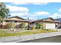 Single-story house with a two-car garage and nicely landscaped yard at 1616 Yellow Rose St, Las Vegas, NV 89108