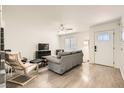 Bright living room with gray sofa, hardwood floors, and a view of the front door at 2433 Olivewood St, Las Vegas, NV 89108