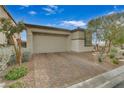 Single-story home with a two-car garage and landscaped front yard at 372 Cooper Hawk Ct, Las Vegas, NV 89138