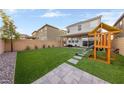 Artificial turf backyard with playset and sitting area at 8766 Victoria Park St, Las Vegas, NV 89148