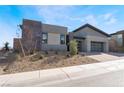 Modern home with gray exterior, two-car garage, and landscaped front yard at 140 Tre Pietre St, Henderson, NV 89011