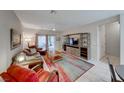 Spacious living room with a leather couch, area rug and built-in shelving at 2535 Evening Twilight Ave, Henderson, NV 89044