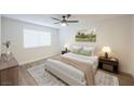 Bright bedroom with a queen-size bed, wood-look flooring, and neutral decor at 6750 Laronda Ln, Las Vegas, NV 89156