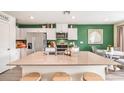 Modern kitchen with island, stainless steel appliances, and green accent wall at 3701 Dolce Vista Ave, Henderson, NV 89044