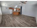 Open living room and kitchen with wood-look flooring and ceiling fan at 416 Bel Air Ave, Pahrump, NV 89048