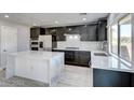 Modern kitchen with dark cabinets, marble countertops, and stainless steel appliances at 4816 Magnolia Blossom Ave, Las Vegas, NV 89131