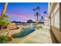 Luxury pool and spa with a waterfall feature at sunset at 62 Incline Village Ct, Henderson, NV 89074