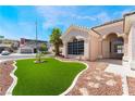 Front yard with artificial turf and desert landscaping at 8644 Highland View Ave, Las Vegas, NV 89145