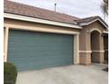 House exterior with teal garage door and landscaping at 5438 Cholla Cactus Ave, Las Vegas, NV 89141