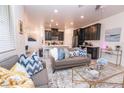 Open concept living room with gray sectional sofa and view of kitchen at 12540 Mosticone Way, Las Vegas, NV 89141