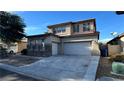 Two-story house with a large three-car garage and landscaped yard at 9151 Edgeworth Pl, Las Vegas, NV 89123