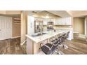 Modern kitchen with white cabinets, stainless steel appliances, and a quartz countertop island at 398 Rushing Creek Ct, Henderson, NV 89014