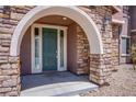 Stone archway entrance with a green door at 8608 Splendid Leaf Ct, Las Vegas, NV 89178