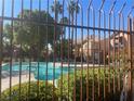 Community swimming pool viewed through a fence at 1050 E Cactus Ave # 2110, Las Vegas, NV 89183