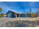 Single story home with gray exterior, solar panels and a gravel yard at 614 Hidden Valley Dr, Henderson, NV 89002