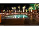 Night view of resort-style pool with lounge chairs and palm trees at 145 Harmon Ave # 704, Las Vegas, NV 89109