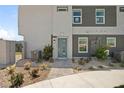 Modern home exterior with a teal front door and landscaping at 4939 Aitana St # 2, Las Vegas, NV 89115