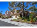 Two-story house with a three-car garage and mature tree in front at 2033 Sedona Creek Cir, Las Vegas, NV 89128