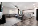 Open living room with sectional sofa, kitchen island, and wood-look floors at 4008 W Le Baron Ave, Las Vegas, NV 89141