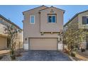 Beige two-story house with a two car garage and landscaping at 4672 Cactus Sun Ln, North Las Vegas, NV 89031