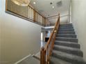 Two-story entryway with a gray carpeted staircase and wooden railing at 6409 Morley Ave, Las Vegas, NV 89108