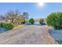 Ranch style home with gravel driveway and mature landscaping at 571 Fehrs Way, Pahrump, NV 89060