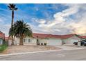 Front view of a single-story house with a red tile roof and a large palm tree at 603 Stonehurst Dr, North Las Vegas, NV 89031