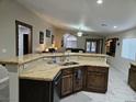 Island kitchen with granite countertops and dark wood cabinets at 6033 Sierra Medina Ave, Las Vegas, NV 89139